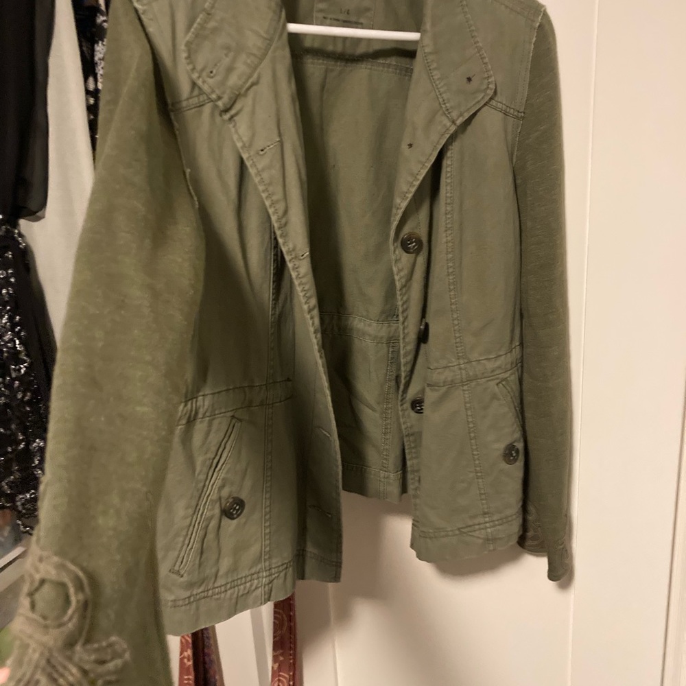 A casual light jacket /blazer with 2 front pockets . Buttons up. Olive green